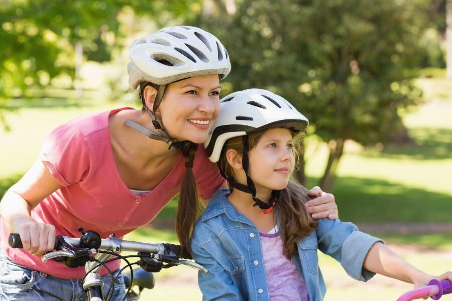 Ein Vater begleitet sein Kind auf dem Fahrrad und zeigt ihm den Weg.