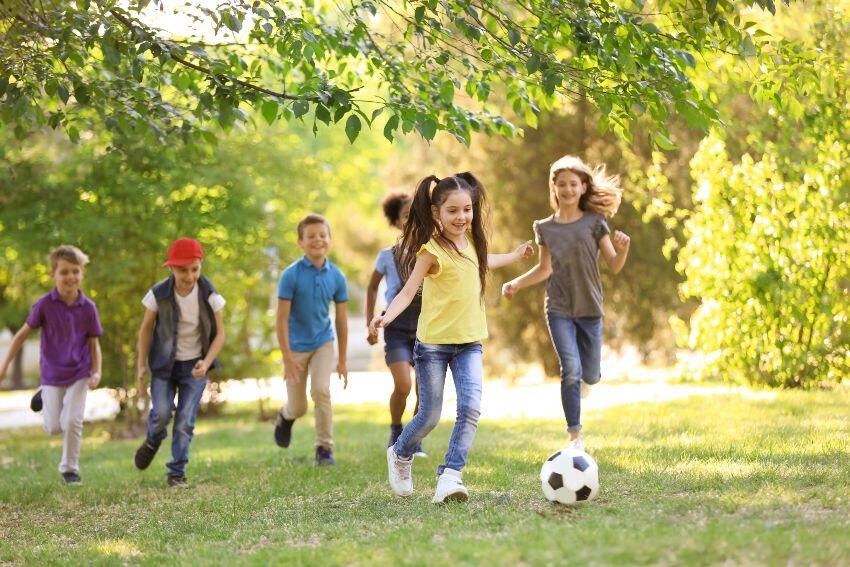 Kinder spielen Fußballl im Park