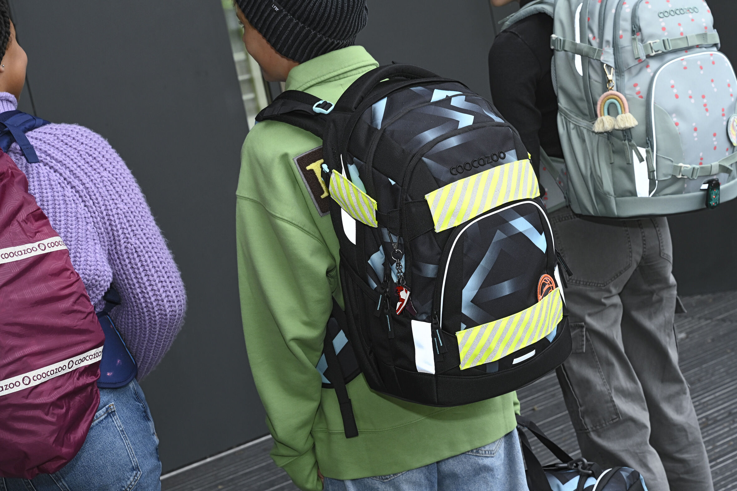 Junge mit reflektierendem Schulranzen für das Gymnasium