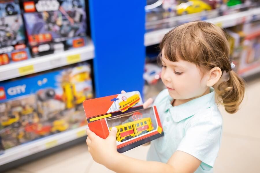 Kleines Mädchen im Spielzeugladen maedchen-spielzeugladen-umgang-mit-geld-lernen