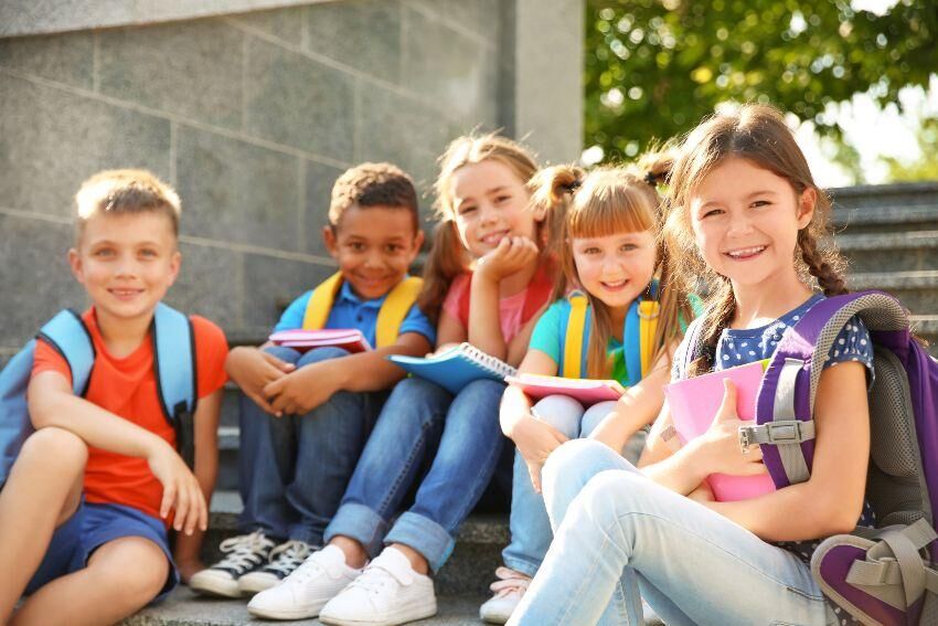 Schulkinder sitzen auf Treppe